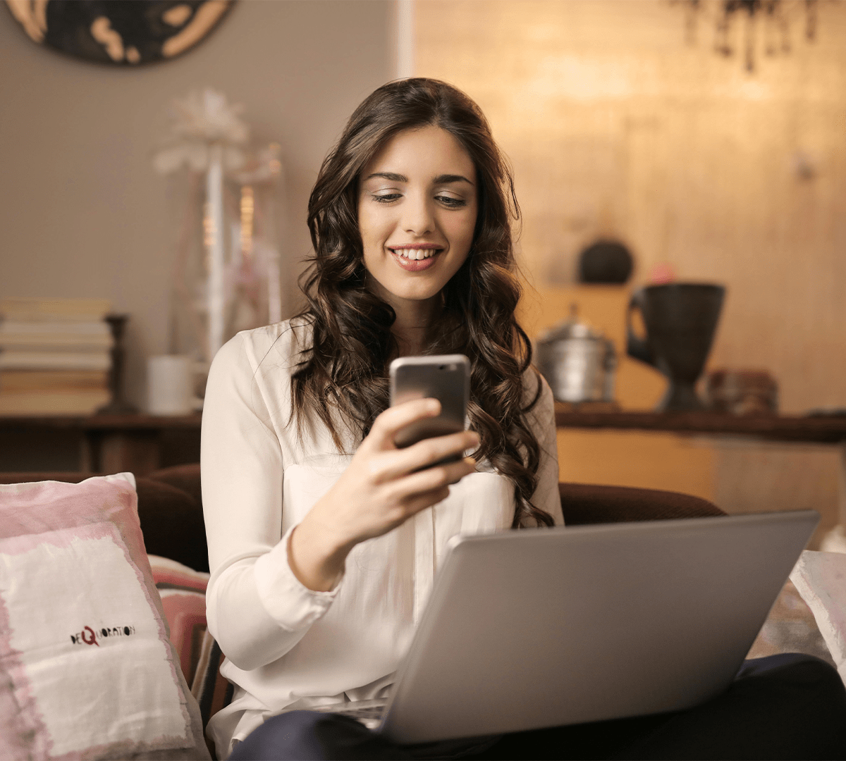 A woman relaxing on a couch, focused on developing her commercialization plan and sales strategy for market success.